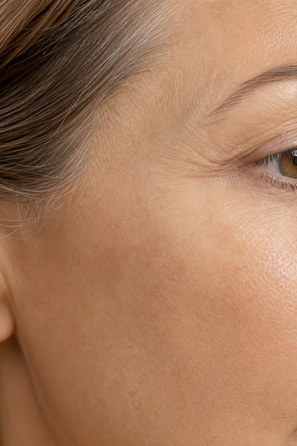 Close-up of naturally textured skin across the cheekbone in soft daylight